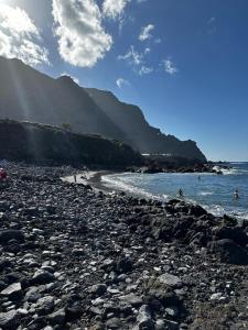 布埃纳维斯塔德尔诺尔特Maravilla en Buenavista的一片岩石海滩,人们在水中游泳