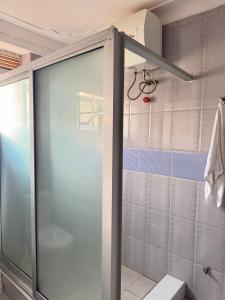 NamugongoKamona Living的浴室里设有玻璃门淋浴