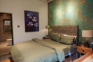 邦美蜀House Of Lens的卧室配有一张床,墙上挂有绘画作品