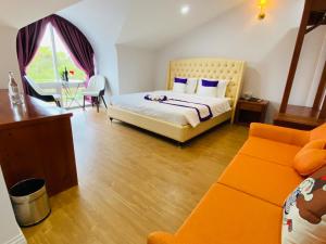 大叻Peach Valley Hotel Dalat的一间卧室配有一张床和一张沙发