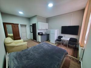 BăcioiARMONIE AIRPORT HOSTEL的小房间设有床、书桌和电视