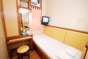 马尼拉Kabayan Hotel Pasay的小房间设有床和电视