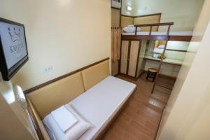 马尼拉Kabayan Hotel Pasay的小房间设有床和小浴室