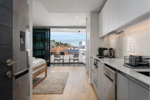 开普敦7 on Bantry Apartments的一间带白色橱柜的厨房和一个阳台。