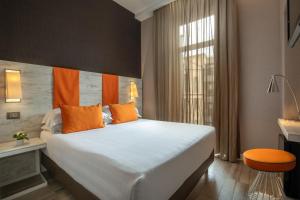 罗马The Guardian的卧室配有带橙色枕头的大型白色床
