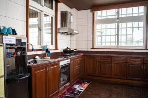 宜兰市宜蘭 星居 包層公寓的厨房配有木制橱柜和黑色冰箱。