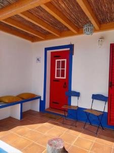 莫托拉Casa dos Corvos的一间设有红色门和两把椅子的房间
