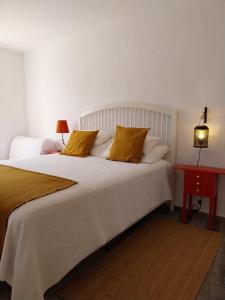 莫托拉Casa dos Corvos的卧室配有一张带黄色枕头的大型白色床。
