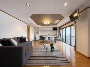 广岛bHOTEL M bld - Beautiful, spacious apartment next to Peace Park的客厅配有沙发和桌子