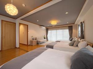 广岛bHOTEL M bld - Beautiful, spacious apartment next to Peace Park的一间带两张床和一张沙发的大卧室