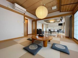 广岛bHOTEL M bld - Beautiful, spacious apartment next to Peace Park的一间带桌子的客厅和一间客厅