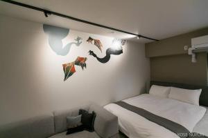 广岛bHOTEL Origaminn 302 - 5 mins PeacePark的一间卧室配有一张床和一张沙发