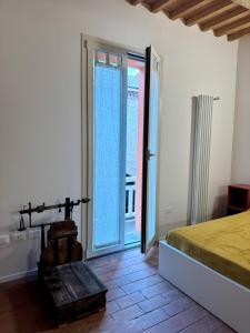 圭尔福堡Casa Viaggi的配有床和滑动玻璃门的房间