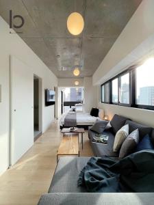 广岛bHOTEL Nekoyard - New Modern Beautiful 1 BR Apartment, Very Near Peace Park, for 6Ppl的客厅配有沙发和1张床