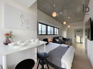 广岛bHOTEL Nekoyard - New Modern Beautiful 1 BR Apartment, Very Near Peace Park, for 6Ppl的一间设有床铺和客厅的房间