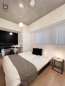 广岛bHOTEL Nekoyard - 1BR Apartment, Good for 6 Ppl, Near Peace Park, WIFI Available的卧室配有一张白色大床和一张书桌