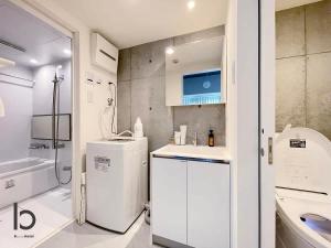 广岛bHOTEL Nekoyard - 1BR Apartment, Good for 6 Ppl, Near Peace Park, WIFI Available的白色的浴室设有水槽和冰箱。