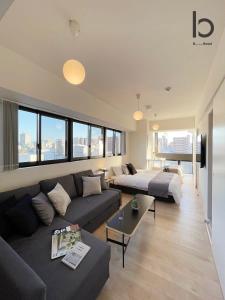 广岛bHOTEL Nekoyard - Lovely 1 BR Apartment, Very Near Peace Park, for 6Ppl的客厅配有沙发和1张床