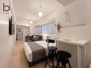 广岛bHOTEL Nekoyard - Lovely 1 BR Apartment, Very Near Peace Park, for 6Ppl的一间卧室配有一张床和一张桌子及两张凳子