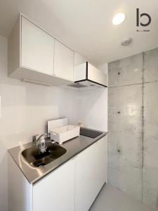 广岛bHOTEL Nekoyard - Lovely 1 BR Apartment, Very Near Peace Park, for 6Ppl的厨房配有白色橱柜和水槽