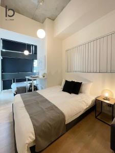 广岛bHOTEL Nekoyard - 1 Bedroom with Loft Good For 7PPL Close To Peace Park的一间卧室配有一张大床和一张桌子