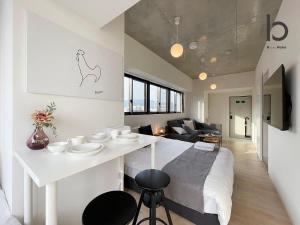 广岛bHOTEL Nekoyard - NEW 1 BR Apartment, Near Peace Park, Good 6Ppl的厨房以及带白色台面的客厅。