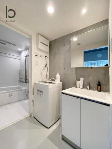 广岛bHOTEL Nekoyard - NEW 1 BR Apartment, Near Peace Park, Good 6Ppl的白色的厨房配有水槽和冰箱