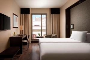 圣克鲁斯-德特内里费NH特内里费酒店的配有一张床、一张书桌和一扇窗户的酒店客房