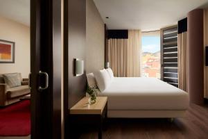 圣克鲁斯-德特内里费NH特内里费酒店的酒店客房设有白色的床和窗户。