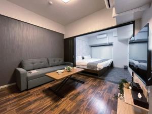 广岛bHOTEL Casaen - Brand New 1BR Apt Near Hondori Shopping District For 6 Ppl的带沙发、床和电视的客厅