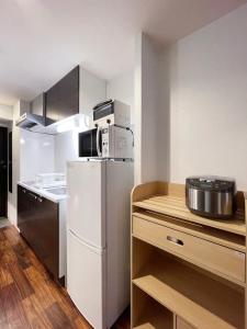 广岛bHOTEL Casaen - Brand New 1BR Apt Near Hondori Shopping District For 6 Ppl的厨房配有白色冰箱和微波炉