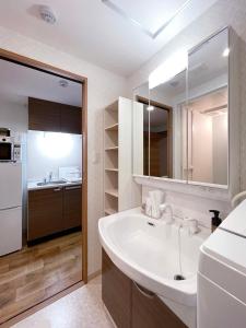 广岛bHOTEL Casaen - 1BR Apartment with beautiful City View Near Shopping District For 6Ppl的白色的浴室设有水槽和冰箱。