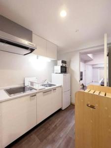广岛bHOTEL Casaen - Cozy 1BR Apt near Hondori District for 6 Ppl的厨房配有白色橱柜和白色冰箱。