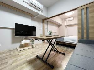 广岛bHOTEL Casaen - 1BR with balcony near Hondori Shopping Arcade, 6PPL的一间设有桌子、电视和床的房间