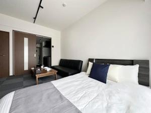 广岛bHOTEL Nagomi - Comfy 1 Bedroom in City Center for 3ppl的一间卧室配有一张大床和一张沙发