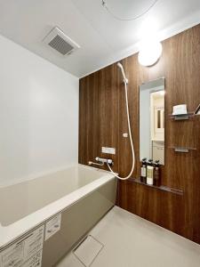 广岛bHOTEL Nagomi - Comfy 1 Bedroom in City Center for 3ppl的带浴缸和镜子的浴室