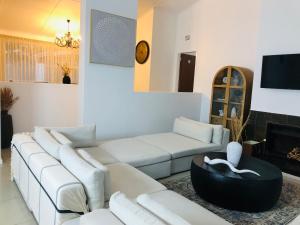 乌姆塔塔Bluebanana Lodge的客厅配有白色沙发和电视