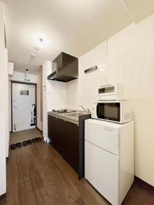 广岛bHOTEL Nagomi - Comfy 1 Bedroom in City Center for 3ppl的厨房配有微波炉和炉灶。