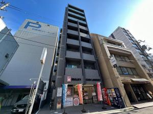 广岛bHOTEL Nagomi - Comfy 1 Bedroom in City Center for 3ppl的前面有停车计数器的高楼