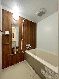 广岛bHOTEL Nagomi - Stylish 1 BR Apt near City Centre for 3Ppl的一间带大浴缸和淋浴的浴室
