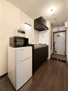 广岛bHOTEL Nagomi - Stylish 1 BR Apt near City Centre for 3Ppl的厨房配有微波炉和冰箱。