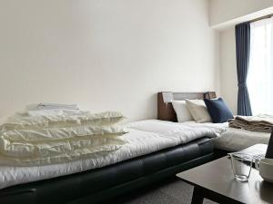 广岛bHOTEL Nagomi - Stylish 1 BR Apt near City Centre for 3Ppl的客厅配有带枕头的沙发