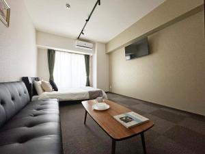 广岛bHOTEL Nagomi - Luxe Apt for 3Ppl City Center的客厅配有沙发和桌子