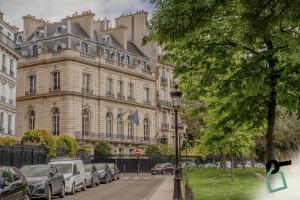 巴黎Hotiday Collection Paris - Arc de Triomphe的一座大型建筑,前面有汽车停放