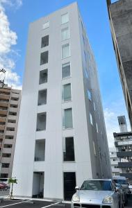 广岛bHOTEL Arts Dobashi - Studio Apt for 6 Ppl Near Peace Park的停在白色建筑前面的汽车