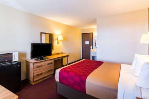 杜马Econo Lodge Dumas的配有一张床和一台平面电视的酒店客房