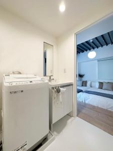 广岛bHOTEL Arts Dobashi - Cozy & Modern Studio Apt 5 Mins Walk to Peace Park的白色的厨房配有水槽和床