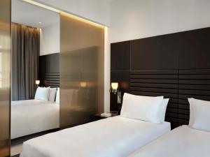 罗马art'otel Rome Piazza Sallustio, Powered by Radisson Hotels的酒店客房,设有两张床和镜子