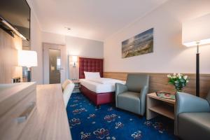 蒂门多弗施特兰德皇家酒店的配有一张床和一把椅子的酒店客房