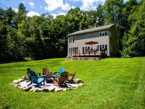 Berkshire Vacation Rentals: High End Berkshires Getaway的坐在房子前面火坑上的一组椅子